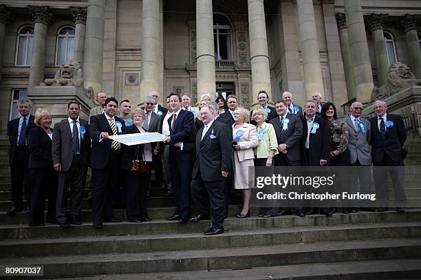 Leader of the Conservative party David Cameron poses with all the tory candidates as he receives a cheque on the steps of Bolton Town Hall on April...