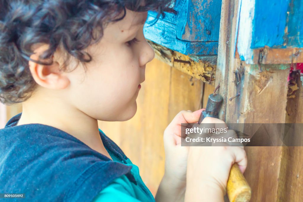 A Young Boy Plays Construction Worker with Hammer, close up