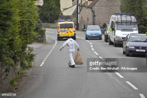 Forensic investigator carries an evidence bag from the scene after two people died in a shooting incident in Westbury-Sub-Mendip, near Cheddar,...