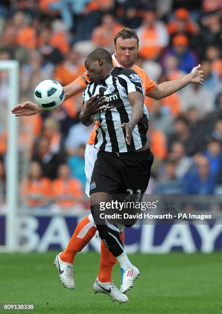 Newcastle United's Shola Ameobi and Blackpool's Ian Evatt battle for the ball during the Barclays Premier League match at Bloomfield Road, Blackpool.
