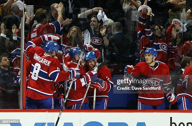 Maxim Lapierre of the Montreal Canadiens looks on as teammates Mike Komisarek, Andrei Markov and Mathieu Dandenault celebrate in the bench area...