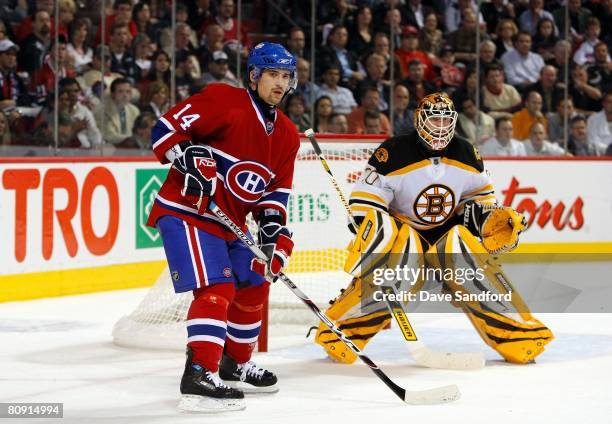 Goalkeeper Tim Thomas of the Boston Bruins defends his net as Tomas Plekanec of the Montreal Canadiens stands to the right of the net during game...