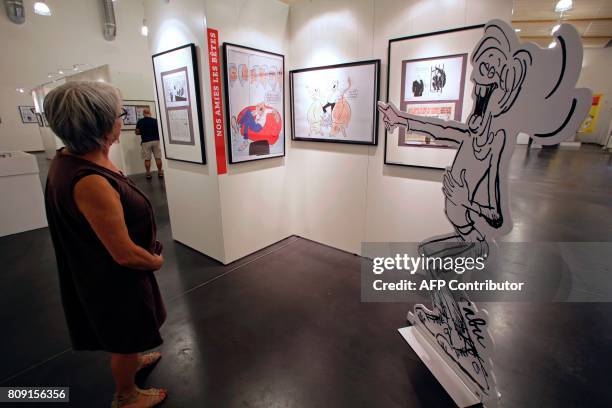 Woman looks at drawings by late French cartoonist Jean Cabut, aka Cabu, killed by jihadists on January 7 in the Charlie Hebdo attack, as she visits...