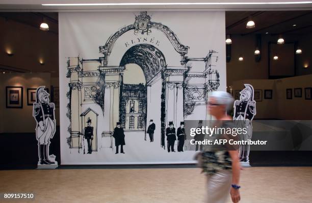 Woman looks at drawings by late French cartoonist Jean Cabut, aka Cabu, killed by jihadists on January 7 in the Charlie Hebdo attack, as she visits...