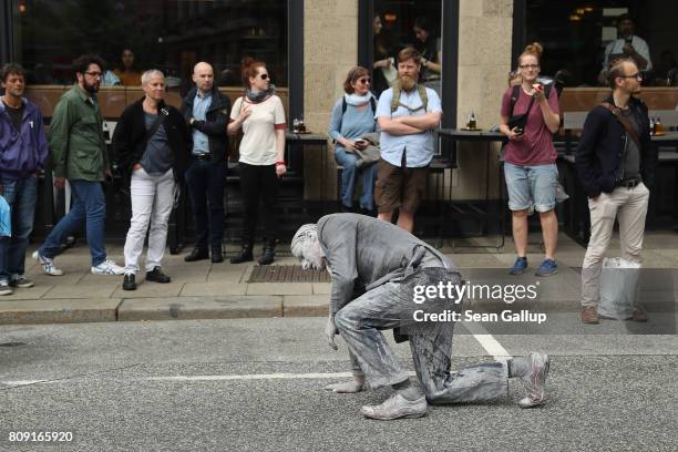 Performance artist covered in clay to look like a zombie walks and stumbles trance-like through the city center on July 5, 2017 in Hamburg, Germany....