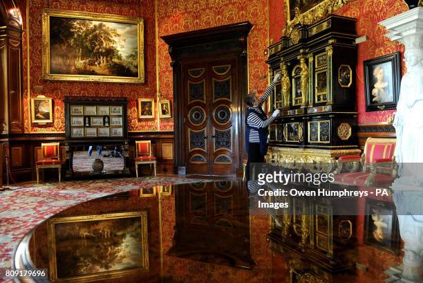 Yvonne Losh a member of the household staff at Alnwick Castle, Northumberland, cleans the world's only pair of &Ocirc;Sun King' Cucci Cabinets,...