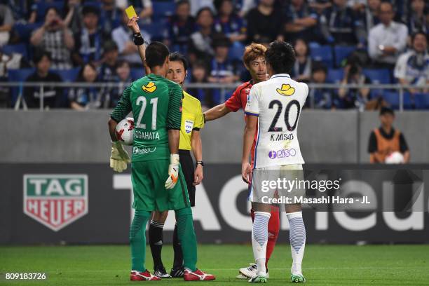 Hitoshi Sogahata of Kashima Antlers is shown a yellow card by referee Hiroyuki Kimura during the J.League J1 match between Gamba Osaka and Kashima...