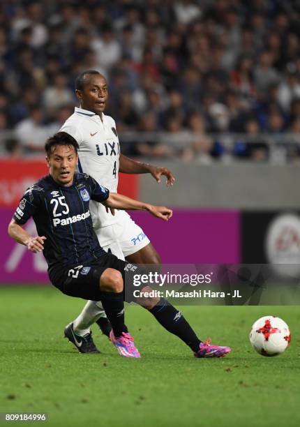 Jungo Fujimoto of Gamba Osaka and Leo Silva of Kashima Antlers compete for the ball during the J.League J1 match between Gamba Osaka and Kashima...