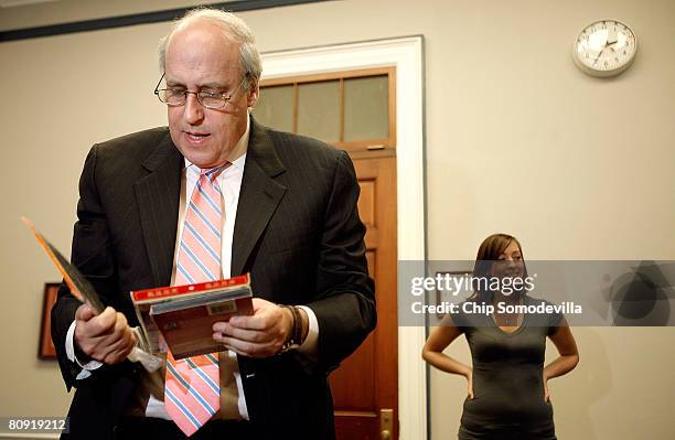 Motion Picture Association of America Chairman and CEO Dan Glickman thumbs through some counterfeit moviess during a demonstration of trained dogs'...