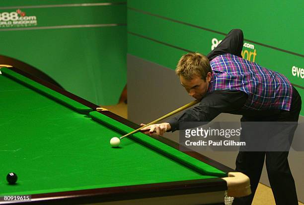 Ali Carter of England pots the black to make a break of 147 against Peter Ebdon of England as Stephen Hendry of Scotland and Ryan Day of Wales...