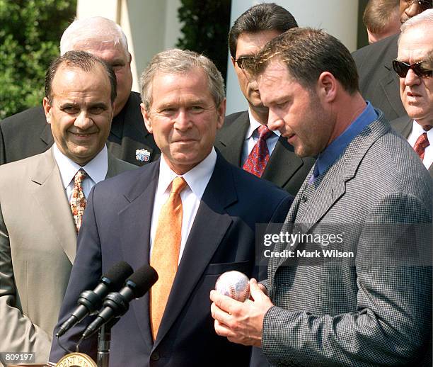 New York Yankee pitcher Roger Clemens, right, presents a baseball to U.S. President George W. Bush as Yankee manager Joe Torre, left, looks on May 4,...