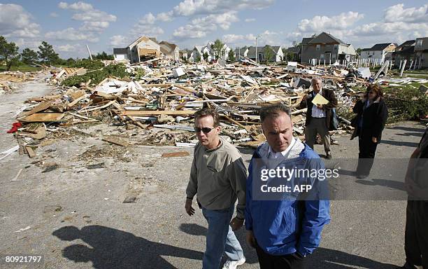 Virginia Gov. Timothy M. Kaine talks with Del. Chris Jones as they walk past debris from a tornado while touring the Hillpoint Farms subdivision...