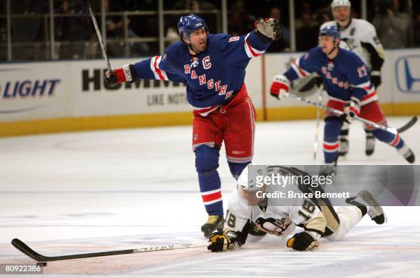 Jaromir Jagr of the New York Rangers hooks Marian Hossa of the Pittsburgh Penguins who dives for the puck during Game 3 of the Eastern Conference...