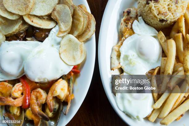 Orders of Mozambique steak tip, left, and frango de casa sit on a table at Cesaria in Boston on Jun. 29, 2017.