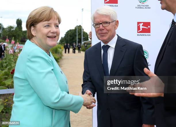 President of the German Football League Reinhard Rauball greets German Chancellor Angela Merkel during the Chinese German football summer camp at...