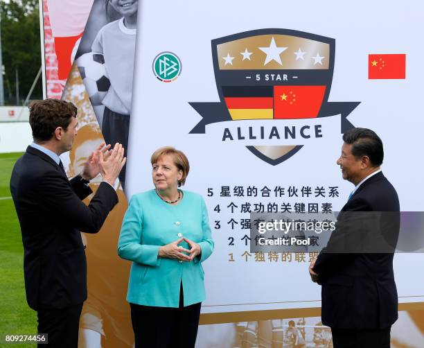 Friedrich Curtius , secretary general of German Football Association , Chinese President Xi Jinping, German Chancellor Angela Merkel, stand in front...