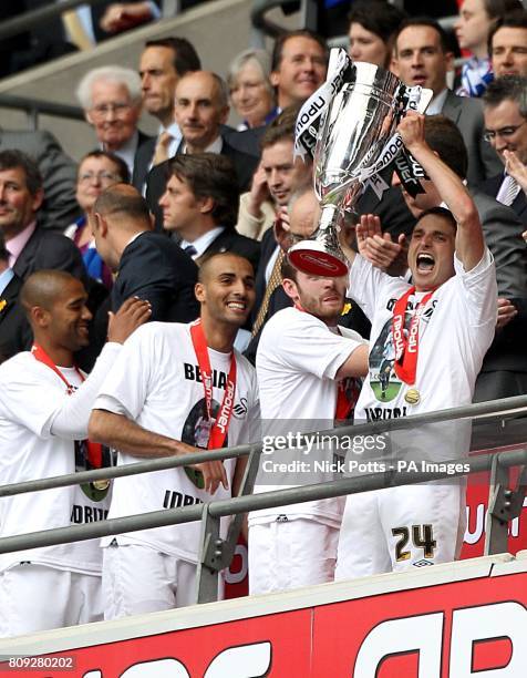 Swansea City's Joe Allen holds the Championship Play Off trophy aloft