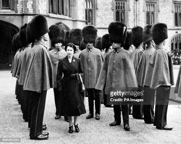 Queen Elizabeth II inspects Grenadier Guardsmen at Windsor Castle, the first ceremonial parade of the Queen's reign.