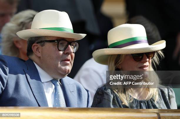 Britain's opposition Labour party seputy Tom Watson wears a sun hat as he watches Britain's Andy Murray play against Germany's Dustin Brown during...
