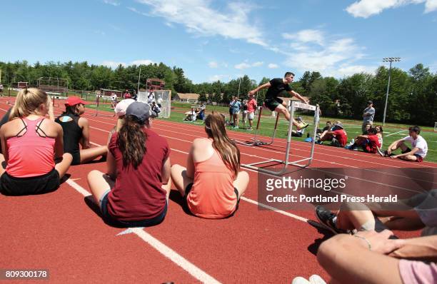 Students and coaches watch while Olympic track athlete Johnathan Cabral runs the hurdles during an instructional practice with former Kennebunk High...