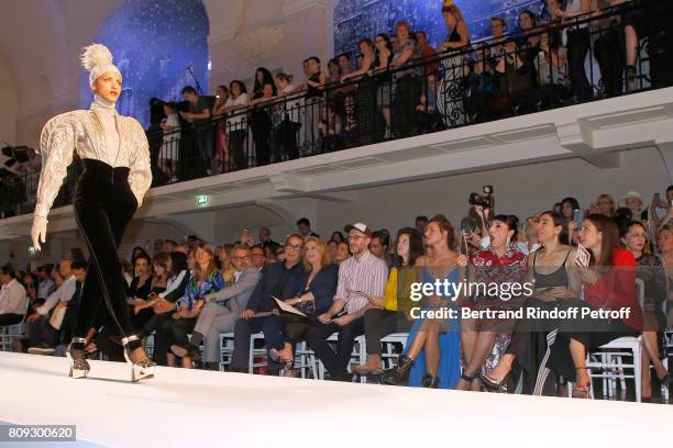 Model Noemie Lenoir walks the runway in front of Farida Khelfa Seydoux, Carla Bruni-Sarkozy, Emmanuelle Alt, Owners of Gaultier Manuel Puig and his...