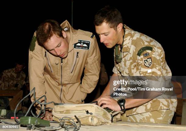 Flying Officer William Wales, Prince William, receives a briefing from Flight Lieutenant Adam Freedman about the downlink receiver used to give real...