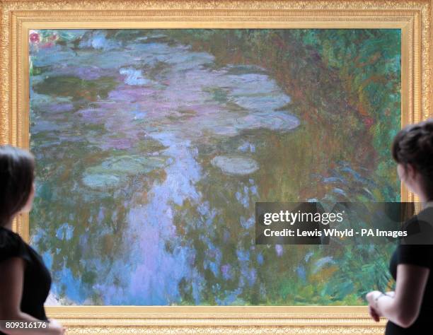 Christie's employees look at Claude Monet's 'Nympheas' or Water Lilies painting at Christie's in London, which is expected to fetch £17 000 to...