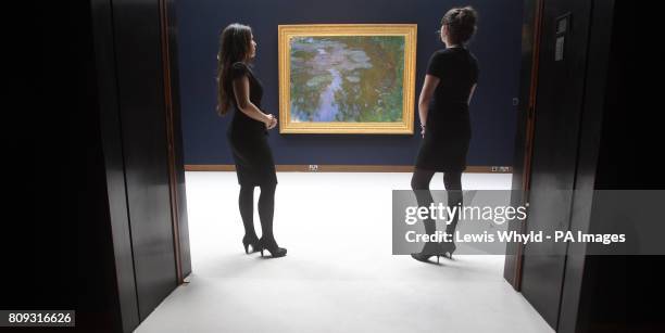 Christie's employees look at Claude Monet's 'Nympheas' or Water Lilies painting at Christies in London, which is expected to fetch 17 000 to 24 000...
