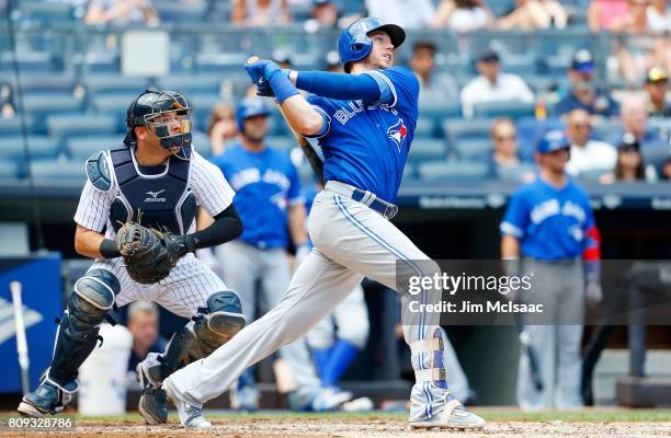 Justin Smoak of the Toronto Blue Jays follows through on a third inning two run home run against the New York Yankees at Yankee Stadium on July 5,...