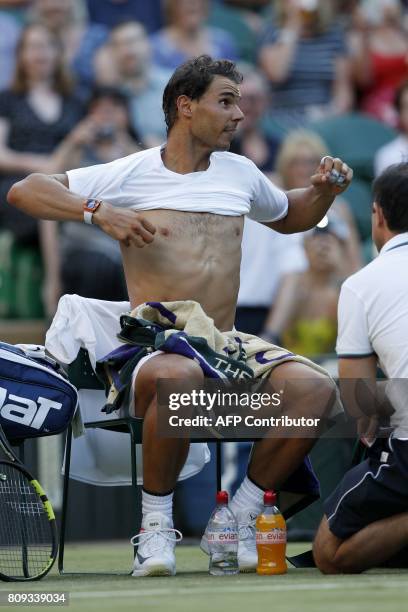 Spain's Rafael Nadal changes his t-shirt during a break in play against US player Donald Young during their men's singles second round match on the...