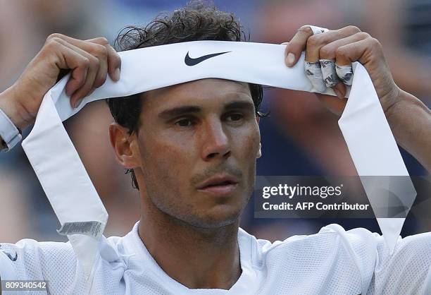 Spain's Rafael Nadal changes his head band during a break in play against US player Donald Young during their men's singles second round match on the...