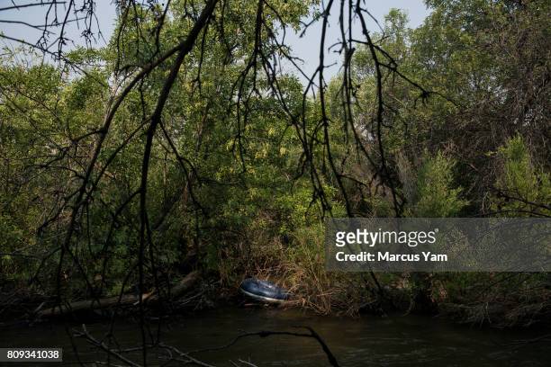 An inflatable tube sits abandoned on quiet inlet of the Kern River, in Kernville, Calif., on July 2, 2017.