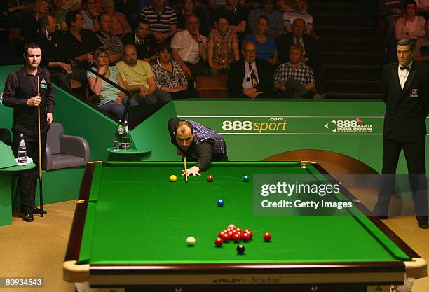 Joe Perry of England breaks against Stephen Maguire of Scotland during the quarter finals of the 888.com World Snooker Championships at the Crucible...