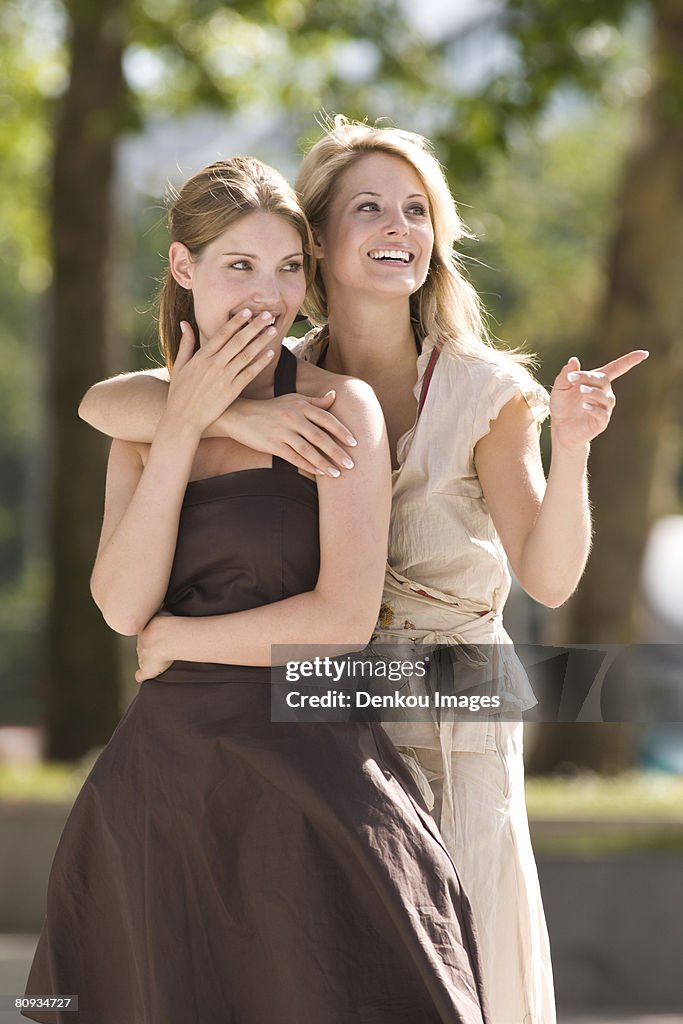 Happy women looking into distance pointing with shocked expression