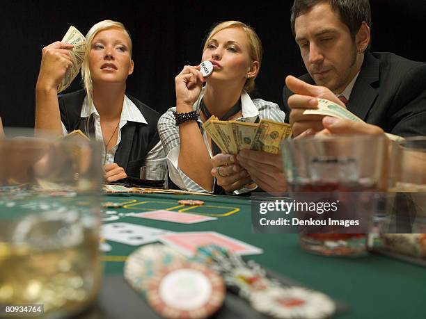 woman kissing dealer button at poker game - poker dealer stock pictures, royalty-free photos & images