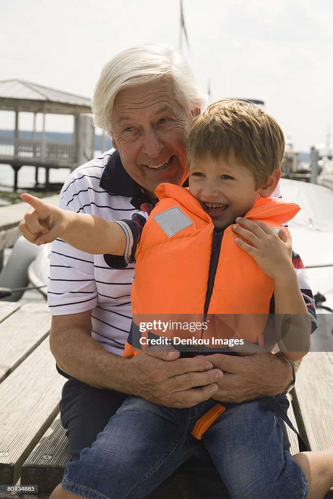 Grandfather and grandson at the lake with boy pointing