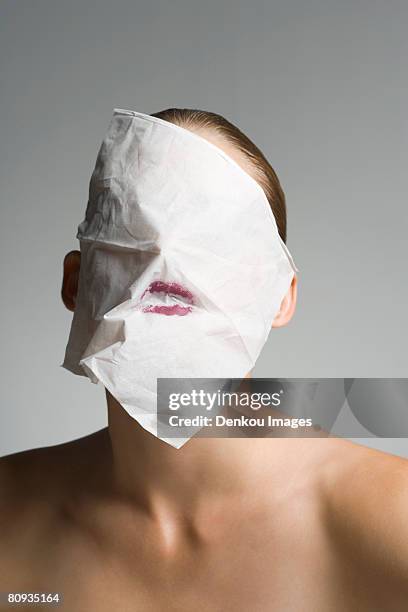 close-up of a young woman hiding her face with a tissue paper - gesicht verstecken stock-fotos und bilder