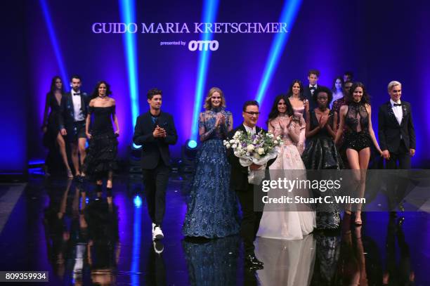 Designer Guido Maria Kretschmer and models acknowledge the applause of the audience the runway during the Guido Maria Kretschmer Fashion Show...