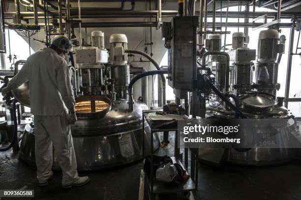 An employee watches as ingredients for body lotion are mixed in a machine at the Natura Cosmeticos SA production facility in the town of Cajamar, Sao...
