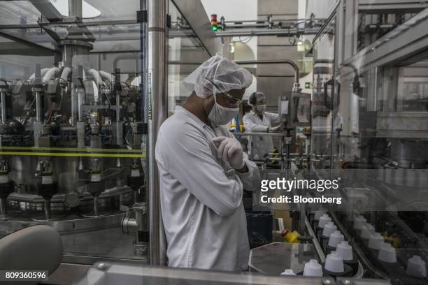 An employee oversees plastic bottles moving through the production line at the Natura Cosmeticos SA production facility in the town of Cajamar, Sao...
