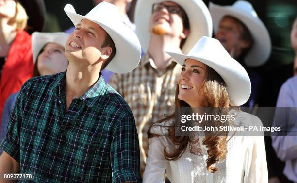 The Duke and Duchess of Cambridge wear matching Stetson hats, as they view ticker-tape start of the Calgary Stampede parade in western Canada.