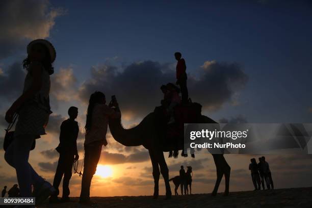 Palestinians ride a camel in the sunset at Gaza beach , in Gaza City, 05 July 2017.