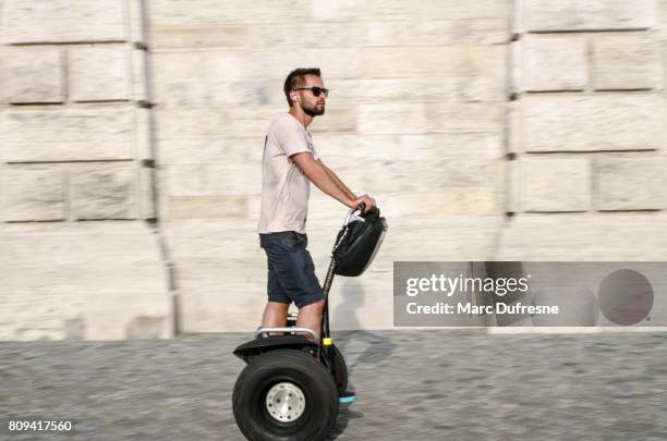 pannen op een man op de segway met enorme band overdag zomer - segway stockfoto's en -beelden