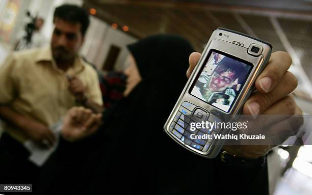 Iraqi Member of Parliament from al-Sadr bloc, Maha Adil, shows a mobile phone picture of a man tortured and killed, allegedly by Iraqi troops in...