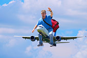 Happy traveler giant man riding outside of airplane