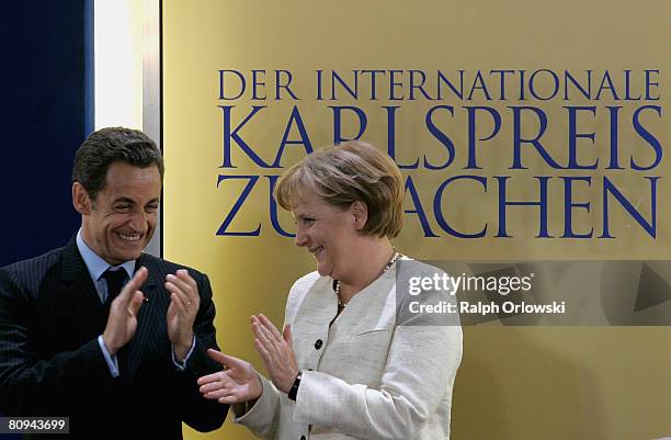 French President Nicolas Sarkozy and German Chancellor Angela Merkel applaud during the Charlemagne Prize ceremony at the city hall on May 1, 2008 in...