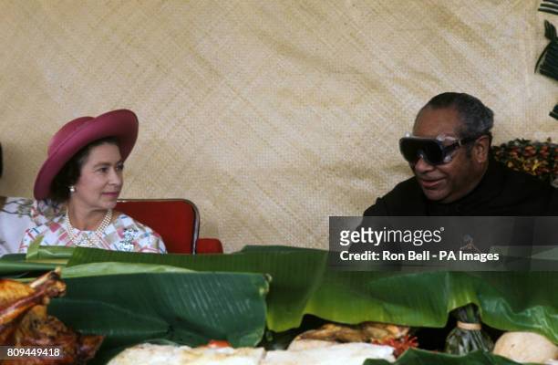 Queen Elizabeth II with King Taufa'ahau Tupou IV of Tonga at a feast at Mala'e Pangai, in the capital, Nuku&#699;alofa
