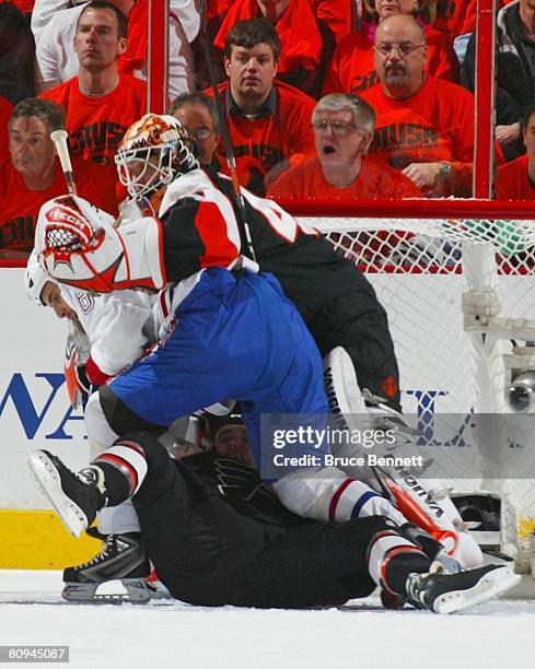 Jim Dowd and goaltender Martin Biron of the Philadelphia Flyers defend against Tom Kostopoulos of the Montreal Canadiens during game three of the...