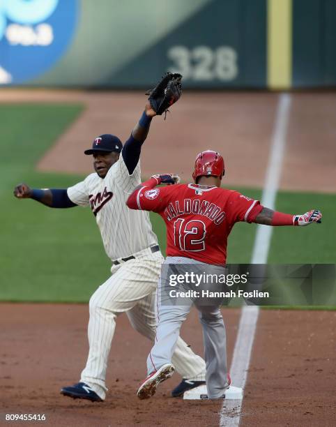 Martin Maldonado of the Los Angeles Angels of Anaheim is out at first base as Miguel Sano of the Minnesota Twins fields the ball during the second...