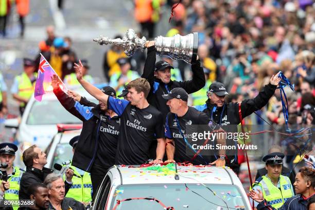 Peter Burling and Grant Dalton celebrate as Glenn Ashby holds the Americas Cup during the Team New Zealand Americas Cup Welcome Home Parade on July...